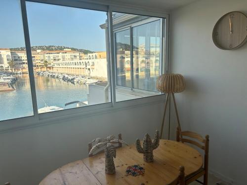 une salle à manger avec une table et une grande fenêtre dans l'établissement Studio au bord de mer, à Sète