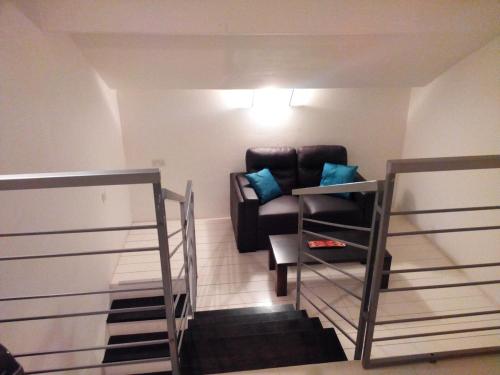 sala de estar con silla de cuero y escaleras en Il-Guva Penthouse at Marsalforn, en Marsalforn