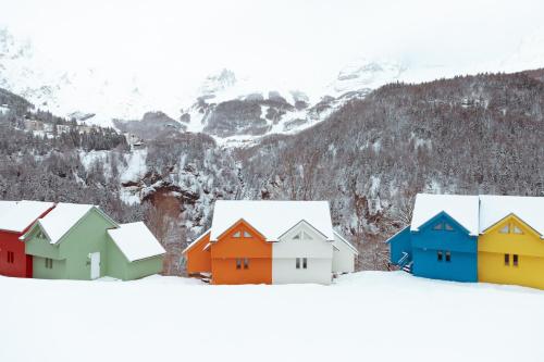 a group of colorful houses in the snow at ISKÖ CHALETS-HÖTEL, Col d'Aubisque in Gourette