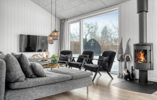 a living room with a couch and a fireplace at Amazing Home In Væggerløse With Sauna in Marielyst