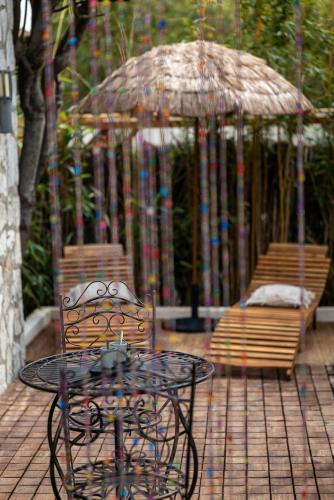 un patio avec deux chaises, une table et un parasol dans l'établissement Studio Terrasse La Roulotte du Tzigane Mandara Beach Antibes Juan-les-Pins, à Juan-les-Pins