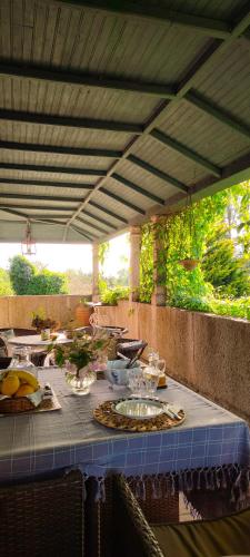 a table with a blue table cloth on a patio at Lugar da Pedra Alta - B&B - Private Historical Villa in Melo