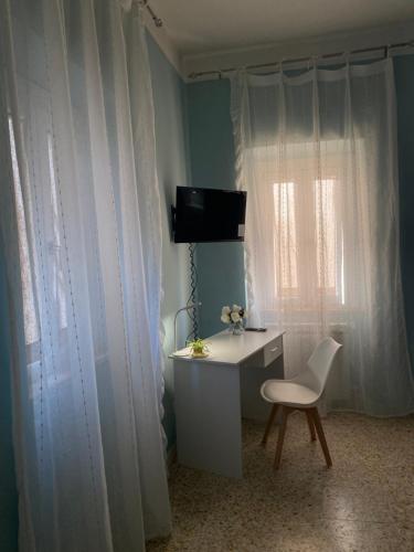 una scrivania e una sedia in una stanza con una finestra di La Bouganville B&B a Sora