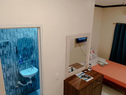 a bathroom with a sink and a shower with a mirror at K.Y.M Pension House in Moalboal