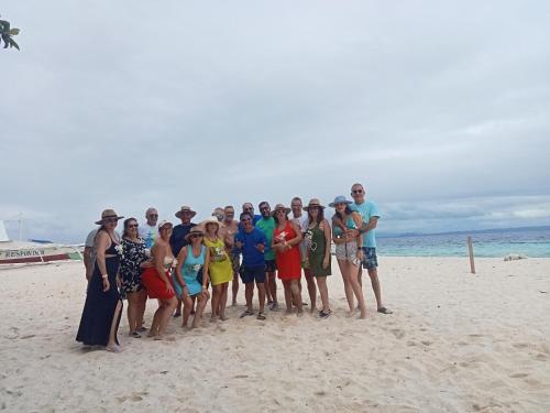 a group of people posing for a picture on the beach at Enas cottages in Pamilacan IsLand in Baclayon