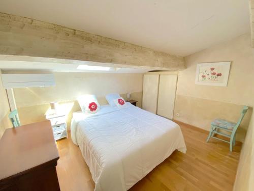 une chambre avec un lit blanc et une chaise dans l'établissement T4 dans résidence avec piscine, à Six-Fours-les-Plages