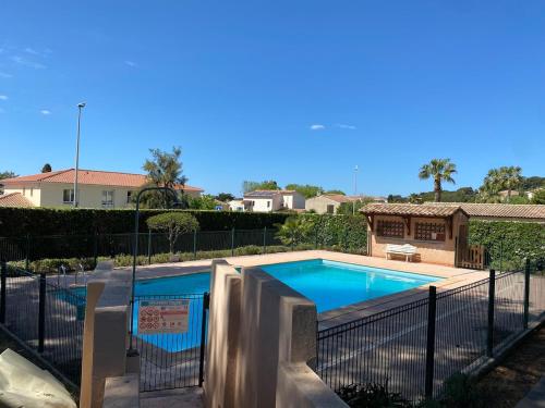 une piscine entourée d'une clôture dans l'établissement T4 dans résidence avec piscine, à Six-Fours-les-Plages