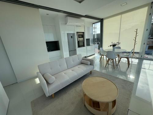 a living room with a couch and a table at Apartamento Cubo de Cristal con piscina y vistas al mar in O Grove