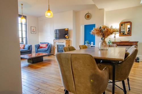 une salle à manger et un salon avec une table et des chaises dans l'établissement Maison de campagne Ervytaine, à Ervy-le-Châtel