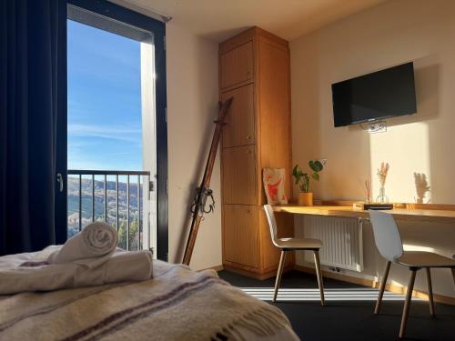 une chambre avec un lit, un bureau et une fenêtre dans l'établissement Caldera hébergement et activités d'altitude, à Saint-Georges
