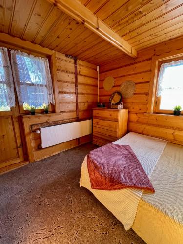 a room with a bed in a wooden cabin at PEŁNA CHATA w Gródku nad Dunajcem in Gródek Nad Dunajcem
