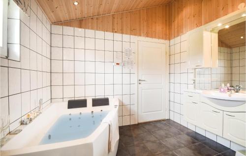 a white bathroom with a tub and a sink at Holiday Home Rørbækvej Ejstrupholm Ii in Krejbjerg
