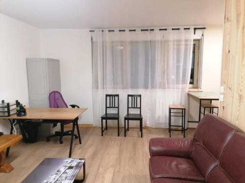 un salon avec un canapé, une table et des chaises dans l'établissement Appt Rouen Centre St Marc-possibilité de parking, à Rouen