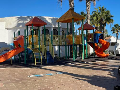 a park with a playground with a slide and slidesktop at Appartement près de la plage in Corralejo