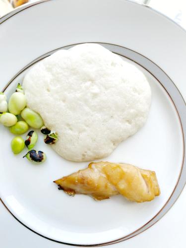 a plate of food with a piece of fish and grapes at Maison Groleau in Mombrier