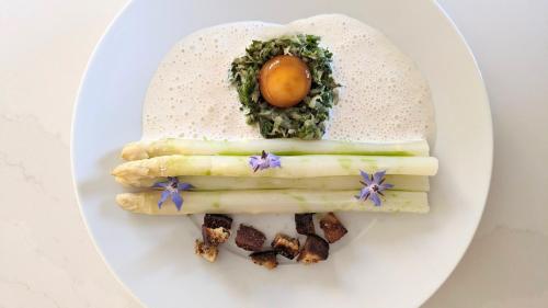 a plate with asparagus and an egg on it at Maison Groleau in Mombrier