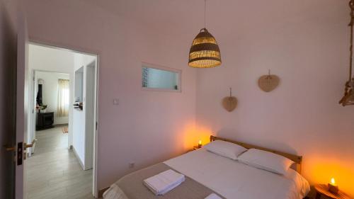 a bedroom with a bed and a pendant light at Vela de Estai in Vila Nova de Milfontes