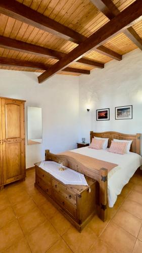 a large bedroom with a large bed and wooden ceilings at Vela de Estai in Vila Nova de Milfontes