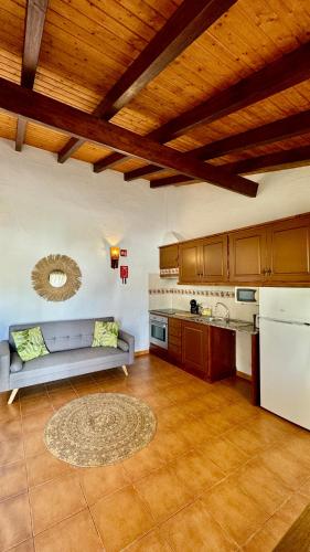 a living room with a couch and a kitchen at Vela de Estai in Vila Nova de Milfontes