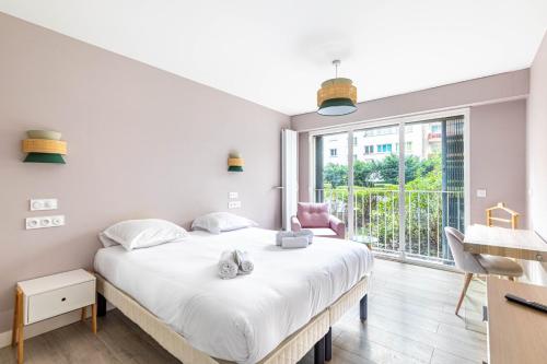 une chambre avec un lit et une grande fenêtre dans l'établissement GuestReady - Charm and Comfort near Champs de Mars, à Paris