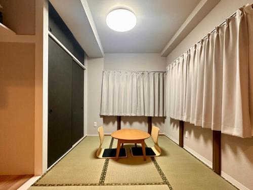 a table and chairs in a room with a window at LoveAsakusaBigSpaceModernHome 浅草寺6分 浅草寺駅10分 2-8人 成田&羽田空港直通 in Tokyo