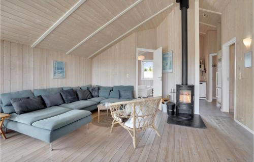 a living room with a blue couch and a fireplace at Holiday Home Bunken 7 in Ålbæk
