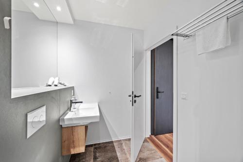 a white bathroom with a sink and a mirror at Hine Adon Fribourg Nord in Fribourg