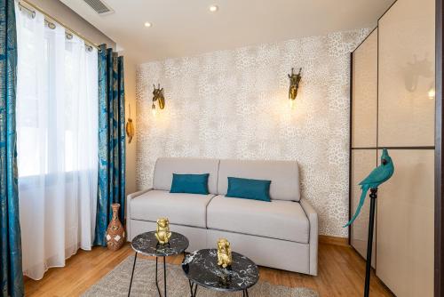 a living room with a couch and two tables at Studio Meublé La Jungle Suite Mandara Beach, Antibes Juan-les-Pins in Juan-les-Pins