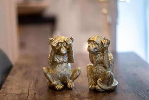 two small bronze figurines of monkeys sitting on a table at Studio Meublé La Jungle Suite Mandara Beach, Antibes Juan-les-Pins in Juan-les-Pins