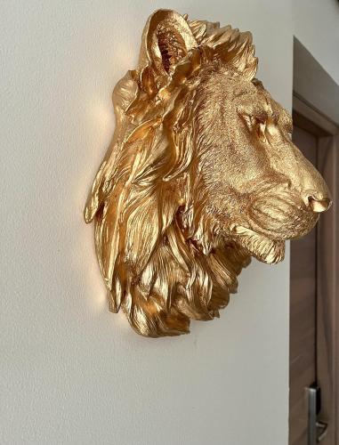 a bronze lion head hanging on a wall at Studio Meublé La Jungle Suite Mandara Beach, Antibes Juan-les-Pins in Juan-les-Pins
