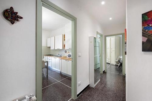 een keuken met witte muren en een deur naar een kamer bij Casa Sole Luna in Arenzano