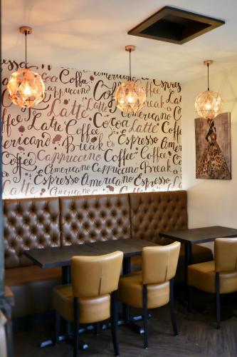 a wall with writing on it in a restaurant with tables and chairs at Abbey Hotel in Leicester