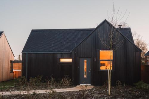 a black house with a black roof at Adam in Newent