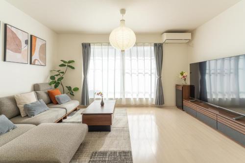 a living room with a couch and a tv at 超值特惠 無料駐車 4ldk戸建 関空 難波 心斎橋 通天閣 スパワールド世界の大温泉 天王寺動物園 京都直通 天下茶屋駅徒歩5分 in Osaka