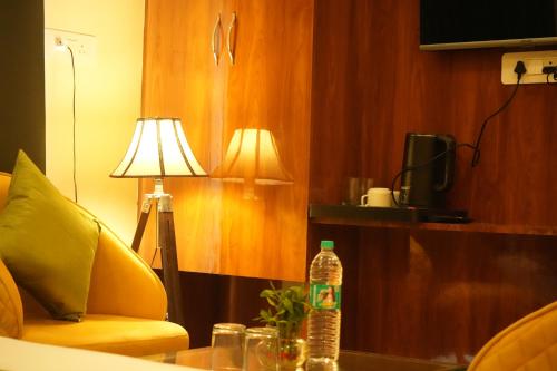 a bottle of water sitting on a table next to a lamp at Traveller's Paradise-Mountain View By Around Stays in Rishīkesh