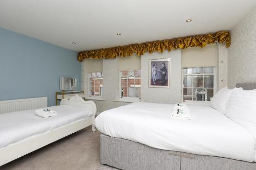 2 camas individuales en una habitación con ventanas en The Captains House, en Liverpool