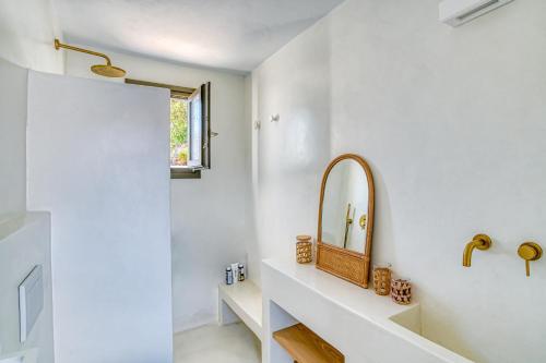 ein Badezimmer mit Spiegel und Waschbecken in der Unterkunft Stone Pine House Antiparos - Private Pool Villa in Andiparos