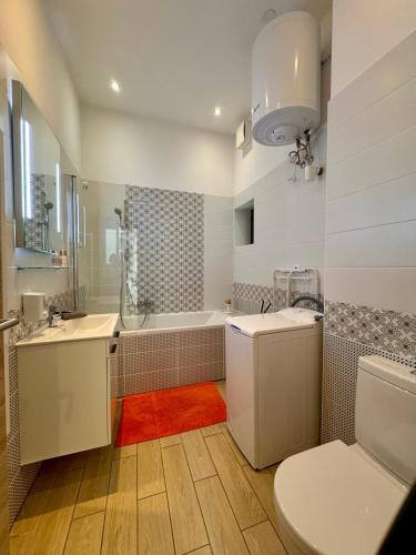a bathroom with a toilet and a sink and a tub at GRACIA APARTMENT HOUSE in Budapest