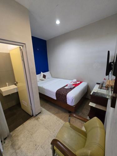 a hotel room with a bed and a chair in it at Kusma Hotel Bandungan Semarang in Semarang