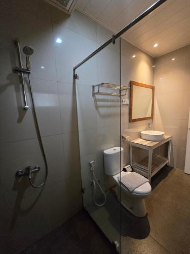 a bathroom with a shower and a toilet and a sink at Kusma Hotel Bandungan Semarang in Semarang