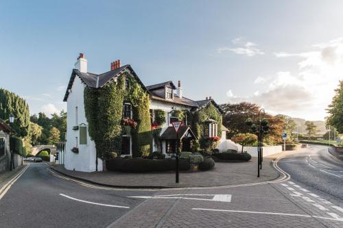 a house covered in ivy on the side of a street at Brig o' Doon House Hotel in Ayr