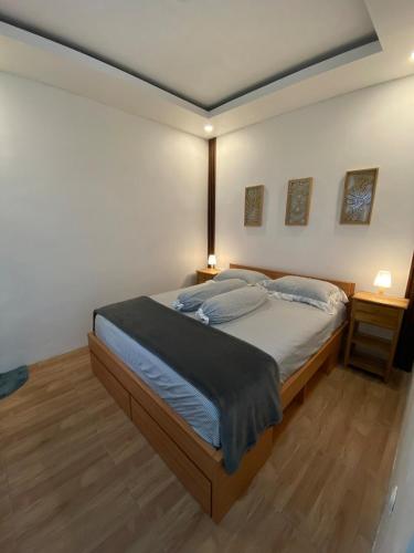 une chambre avec un grand lit et deux tables de nuit dans l'établissement CorriDoor Daily Homestay, à Bandung