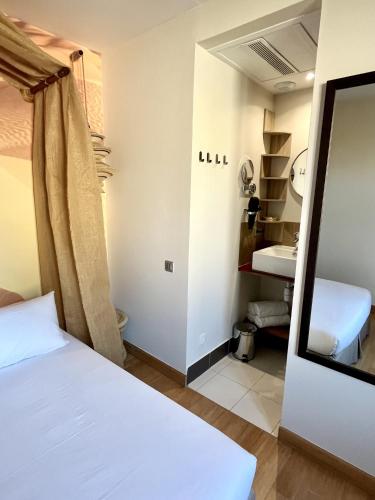 une petite chambre avec un lit et un miroir dans l'établissement Appartement 4 pers - La Caravane du Touareg - Mandara Beach, Antibes - Juan-les-Pins, à Juan-les-Pins