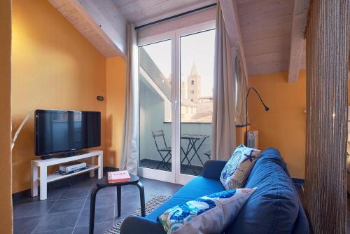 a living room with a blue couch and a large window at Italianway - Tra le Torri in Albenga