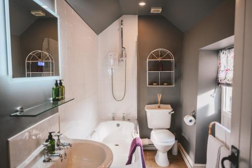 une salle de bain avec un lavabo, des toilettes et une baignoire dans l'établissement Nurse's Cottage, Tissington, Derbyshire, à Ashbourne