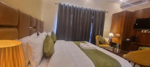 a bedroom with a large bed with a desk and a window at Traveller's Paradise-Mountain View By Around Stays in Rishīkesh