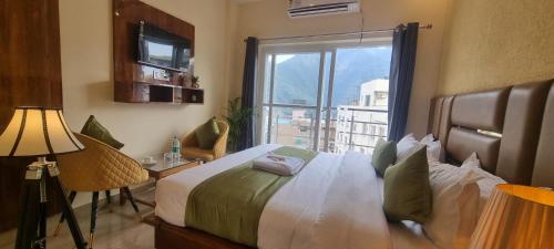 a bedroom with a bed with a large window at Traveller's Paradise-Mountain View By Around Stays in Rishīkesh