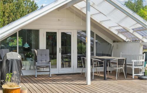 a conservatory with a table and chairs on a deck at 4 Bedroom Stunning Home In Kalundborg in Kalundborg