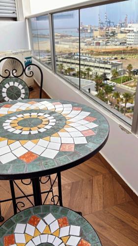 two tables with mosaics on them in front of a window at osuite in Ashdod