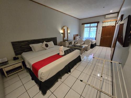 a bedroom with a large bed and a living room at Kusma Hotel Bandungan Semarang in Semarang